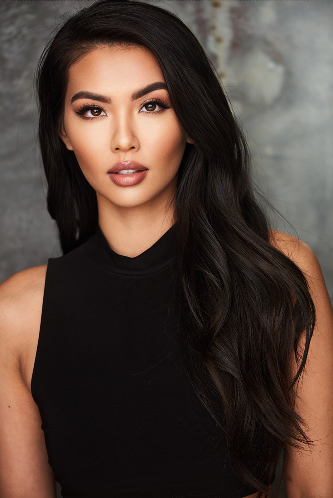 A woman with glamorous waves and confident makeup in an editorial portrait, looking calm and self-assured