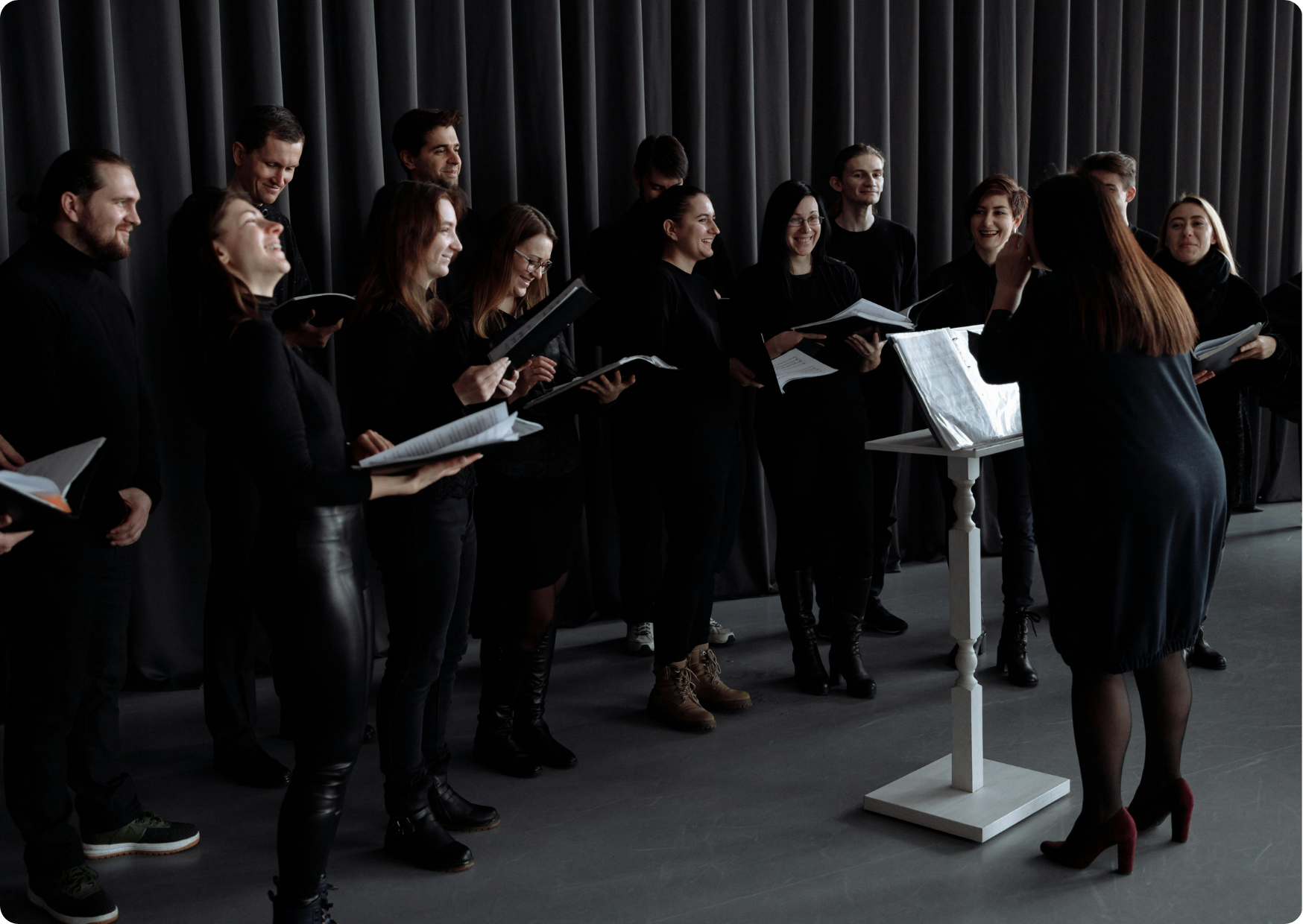 Blog Aude Compose - Cheffe de chœur et choristes souriants habillés en costumes de scène lors d'une répétition