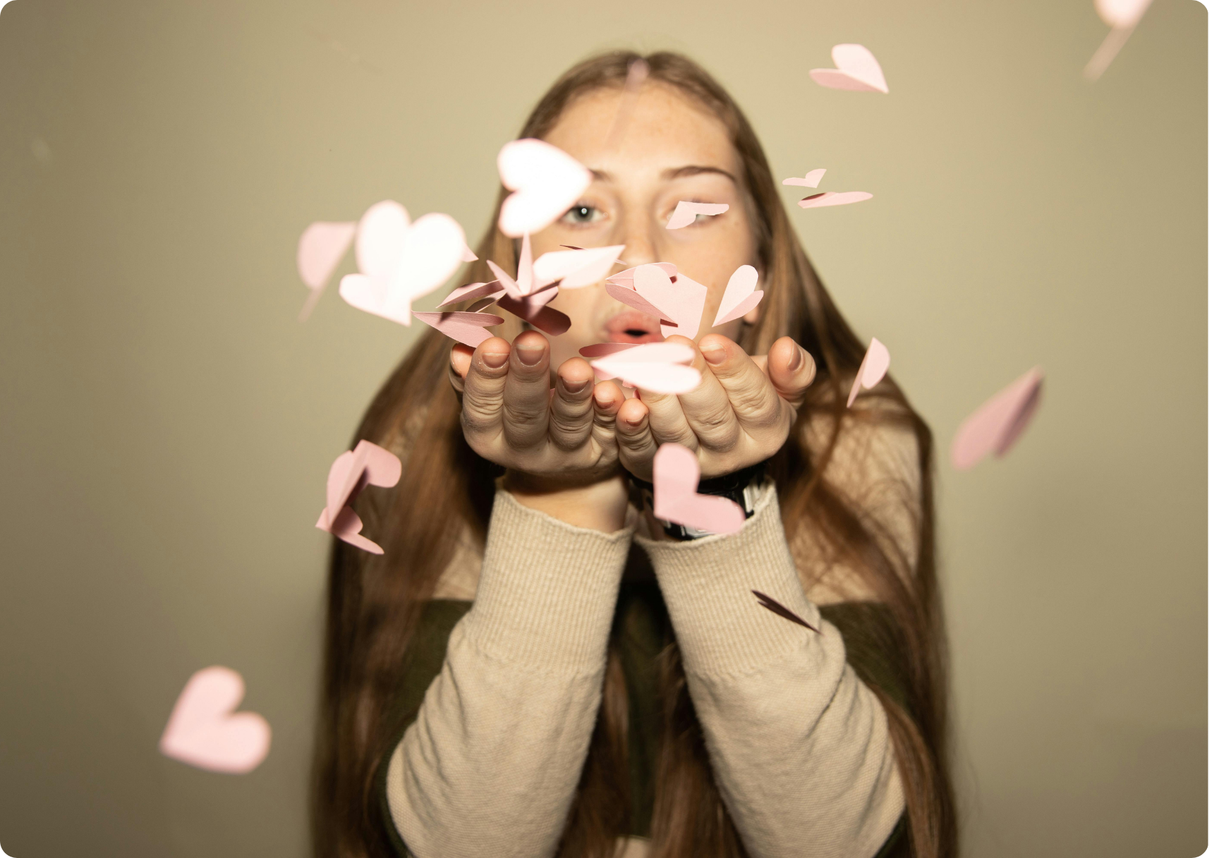 Blog Aude Compose - Jeune femme souffle des confettis en forme de cœur rose