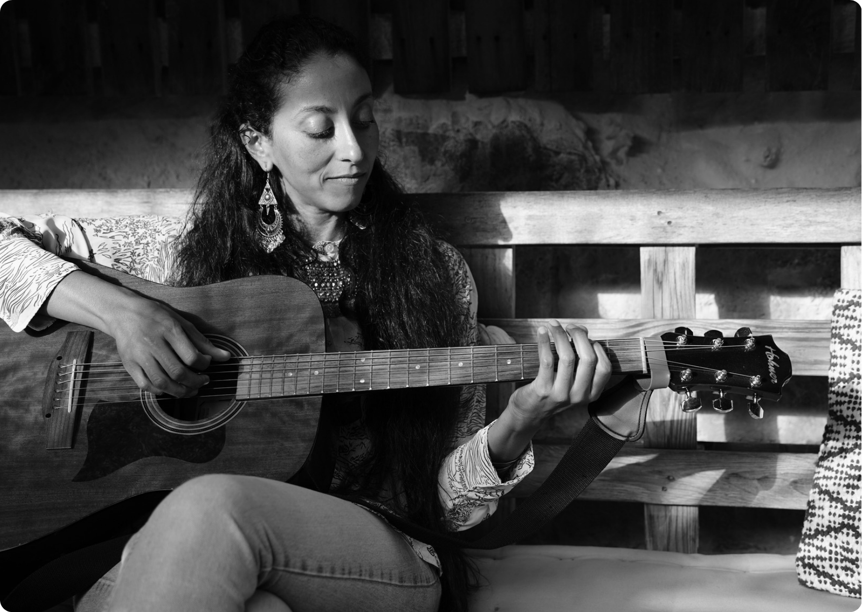 Blog Aude Compose - Artiste Najoi en train de jouer de la guitare et dans ses pensées, photo en noir et blanc