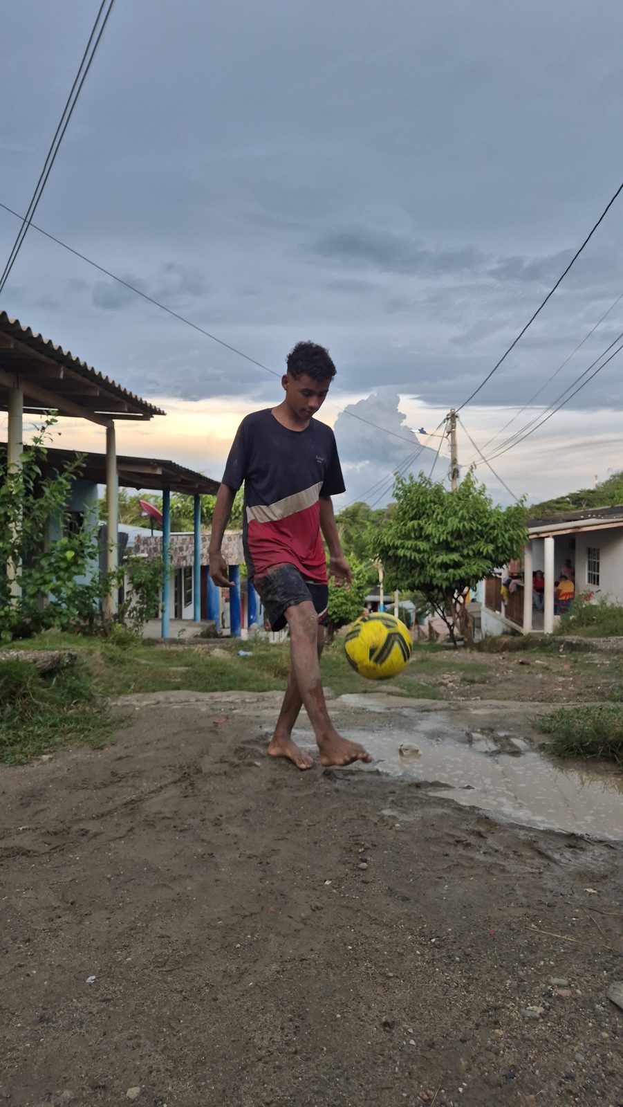 A barefoot footballer at dusk