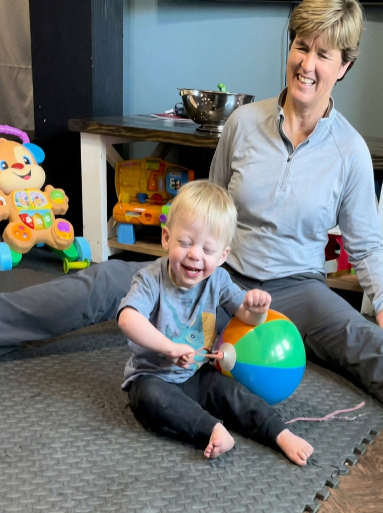 Claudia working joyfully with a child in his home
