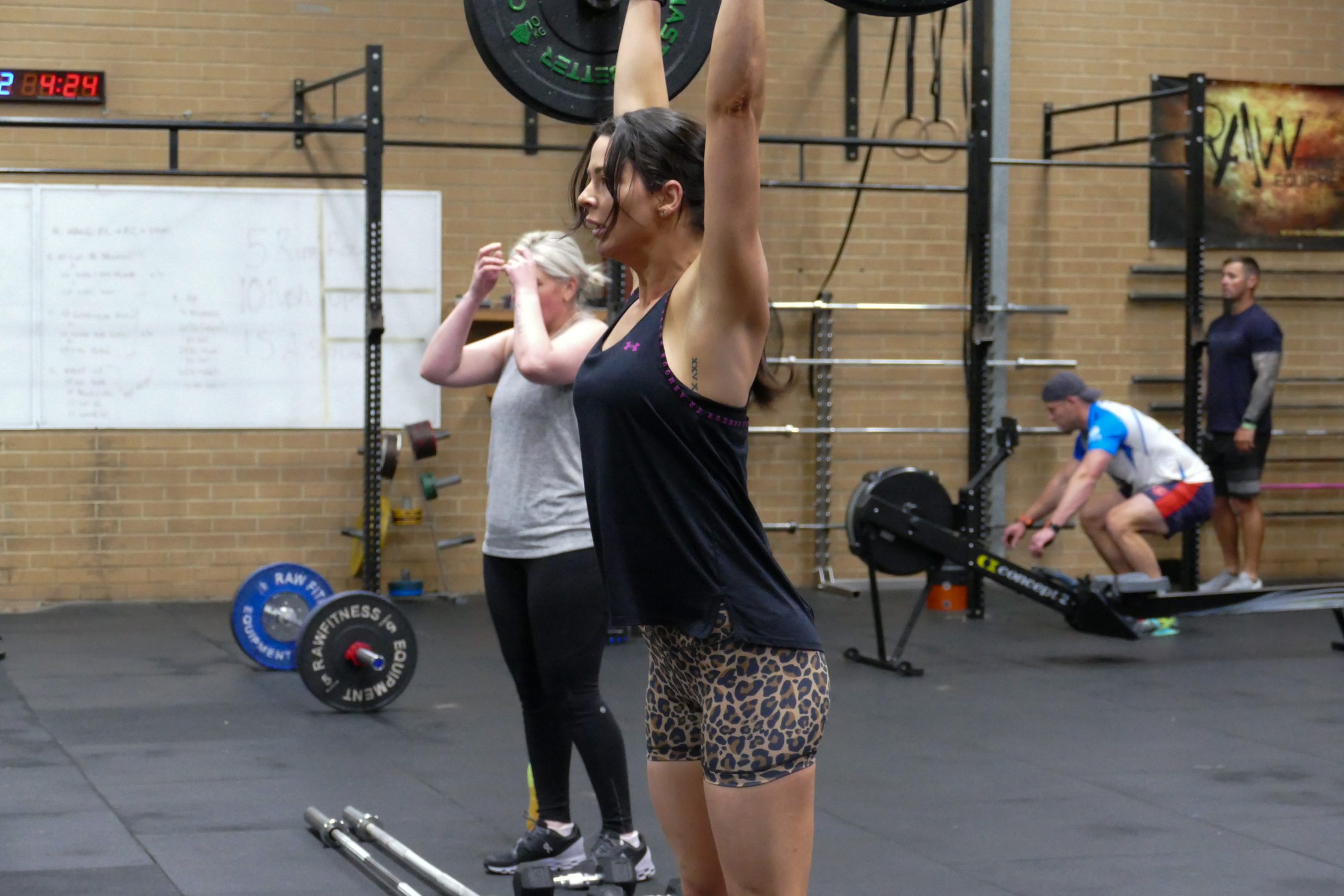 Members pressing overhead during a class at CrossFit SFS