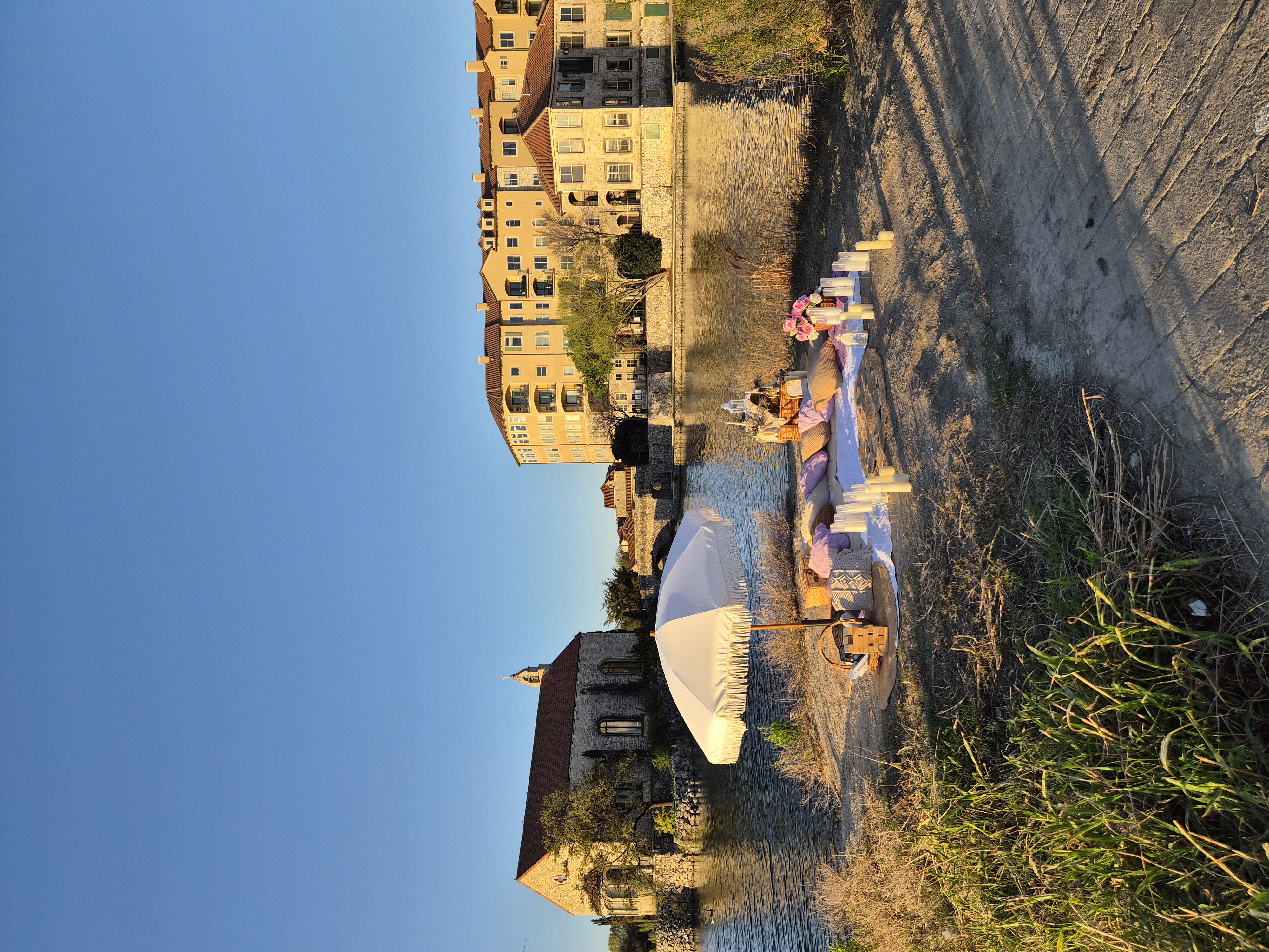 Riverside picnic with white umbrella and European setting