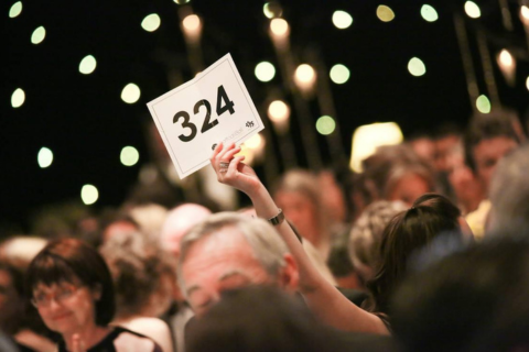 Person holding up a bid card at a fundraiser