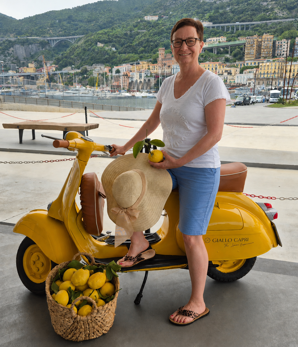 Marita Hansel auf Kreuzfahrt mit der NORWEGIAN VIVA; sitzt auf einem gelben Roller mit Zitronen vor der Kulisse von Salerno