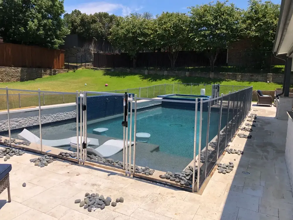 Black mesh safety fence around a backyard pool