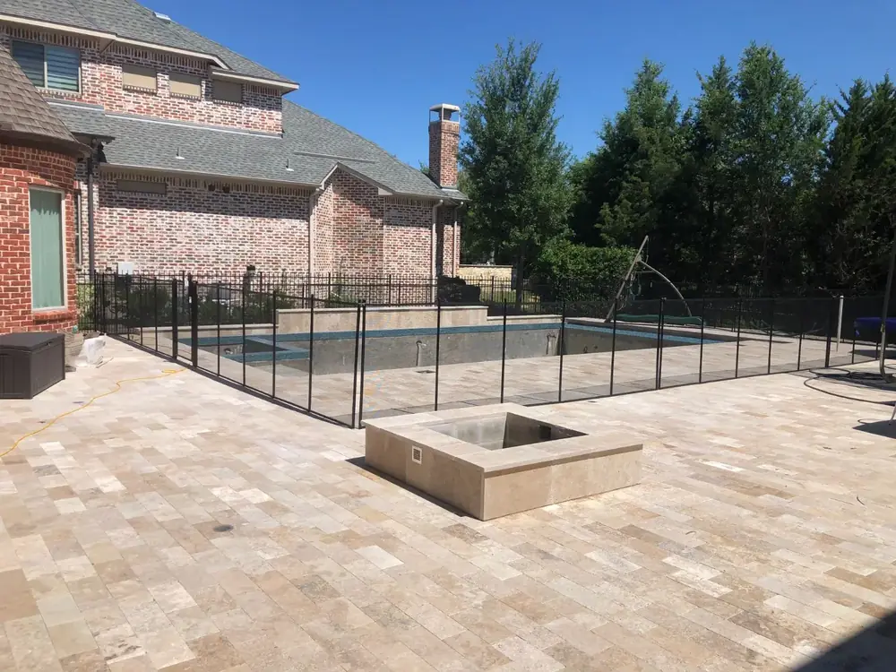 Black mesh safety fence around a backyard pool