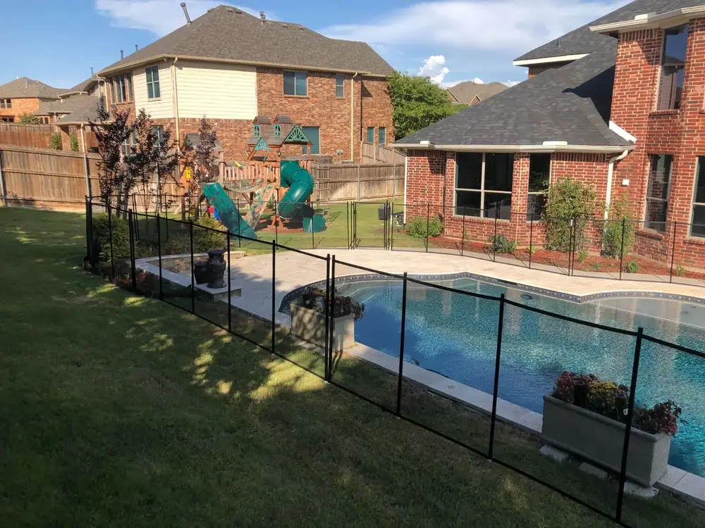 Black mesh safety fence around a backyard pool