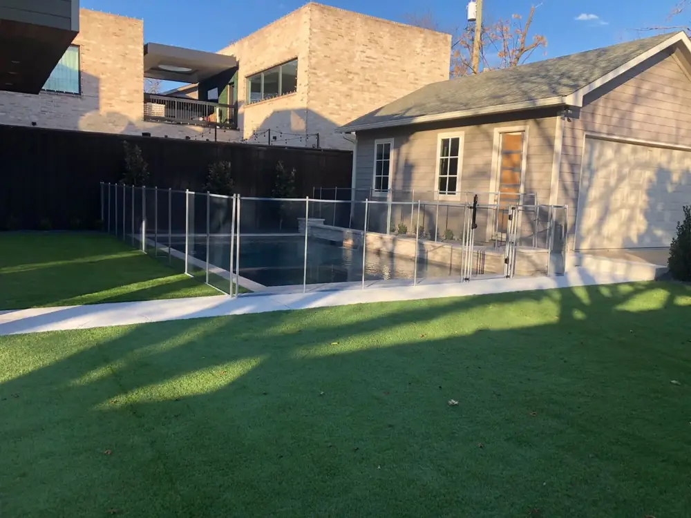 Black mesh safety fence around a backyard pool