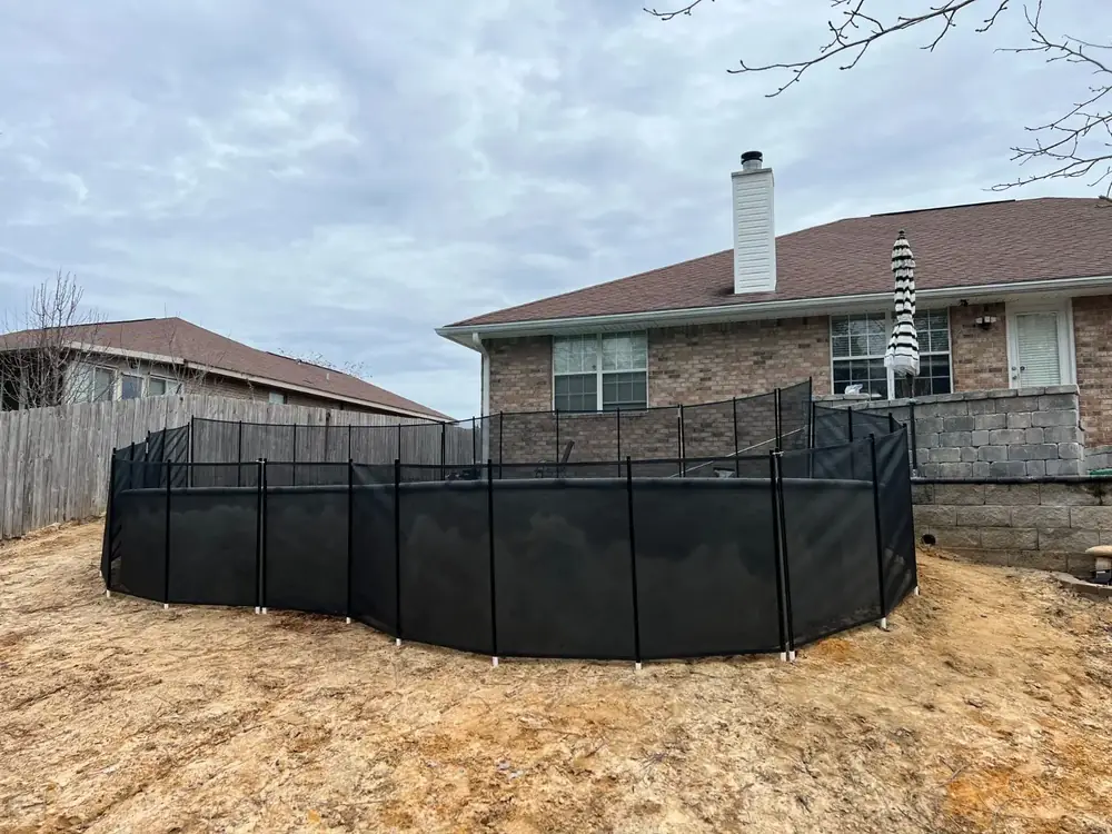 Black mesh safety fence around a backyard pool