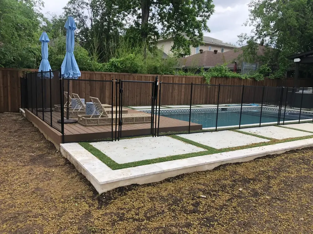 Black mesh safety fence around a backyard pool
