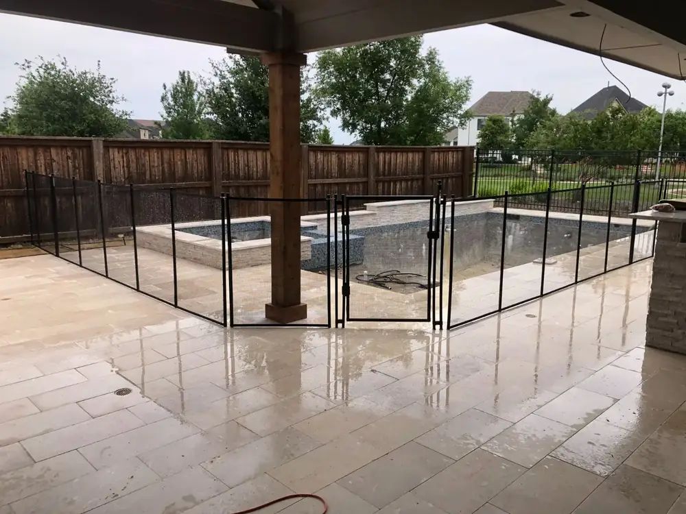 Black mesh safety fence around a backyard pool