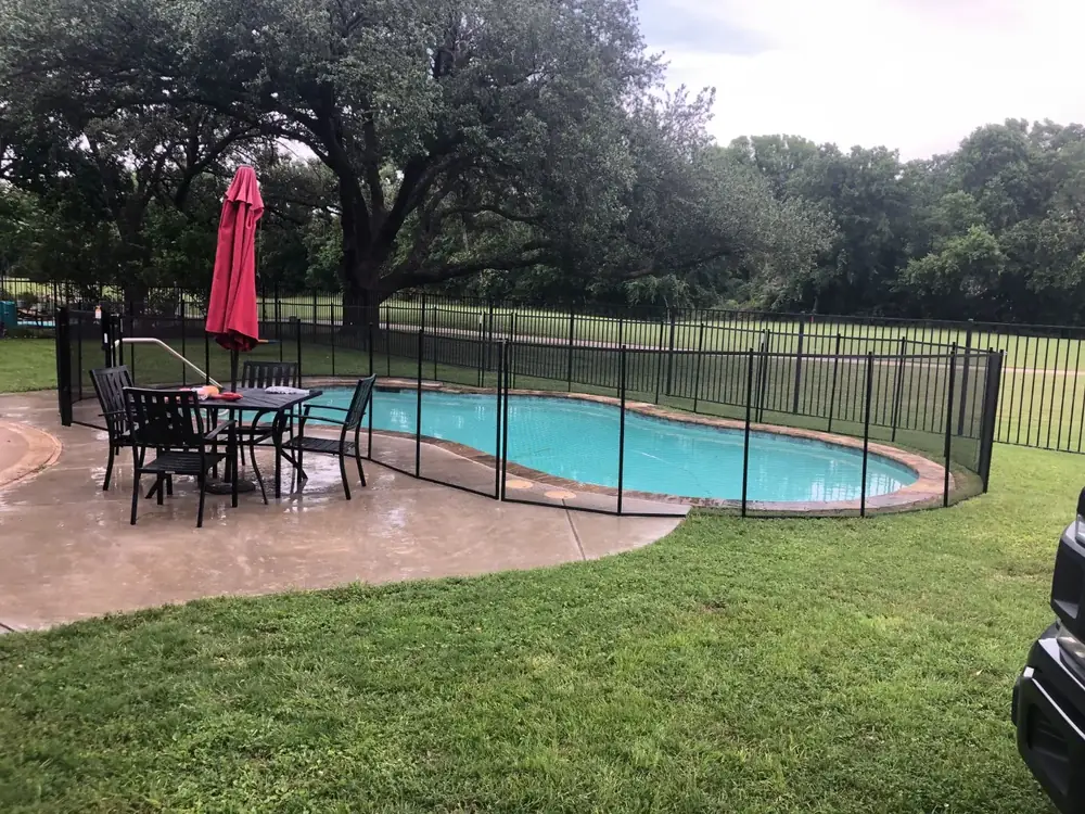 Backyard pool with black safety fence