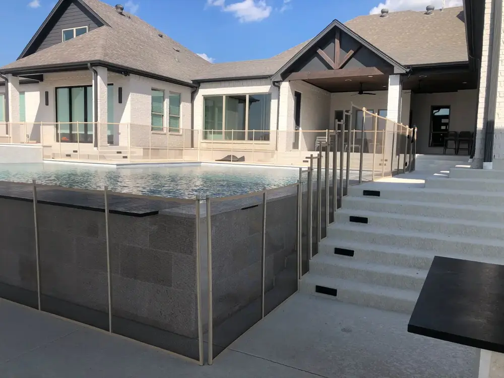 Tan mesh safety fence that blends with stone and deck