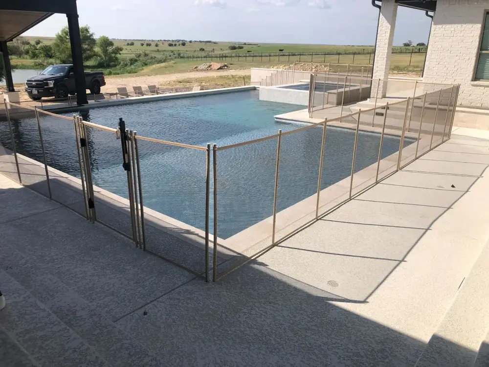 Tan mesh safety fence that blends with stone and deck