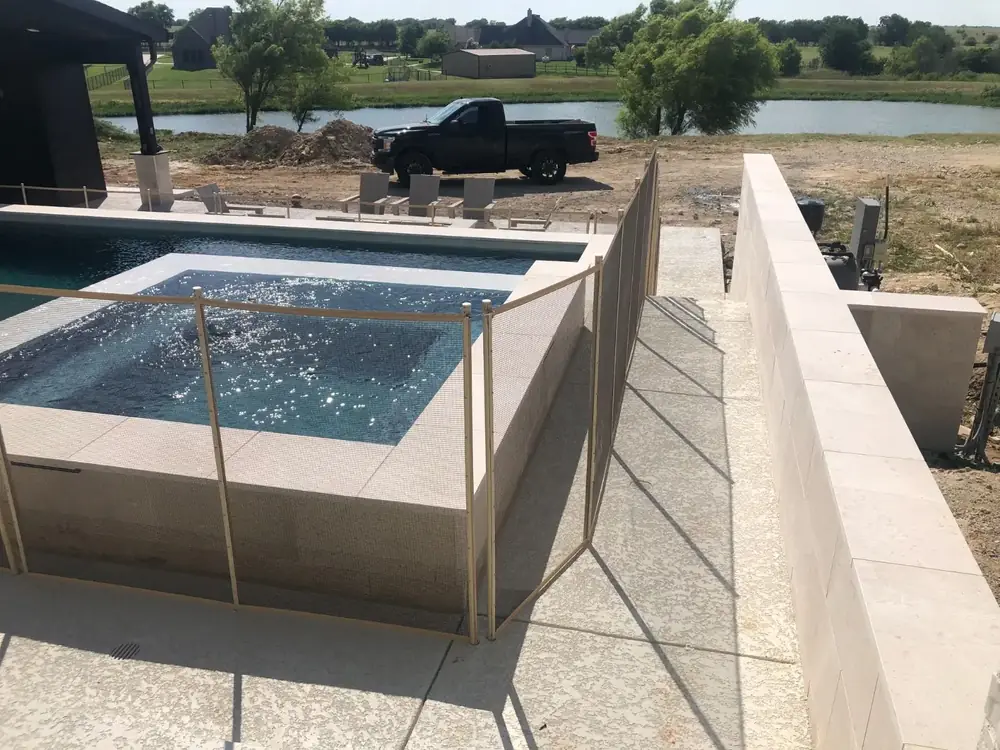 Tan mesh safety fence that blends with stone and deck