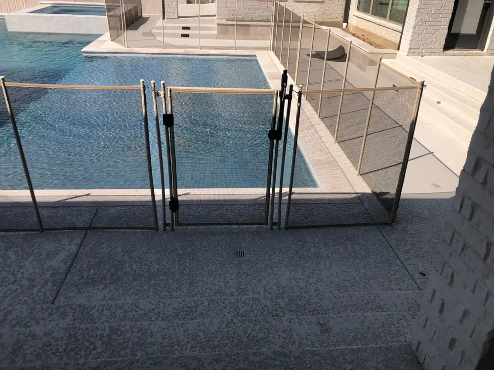 Tan mesh safety fence that blends with stone and deck