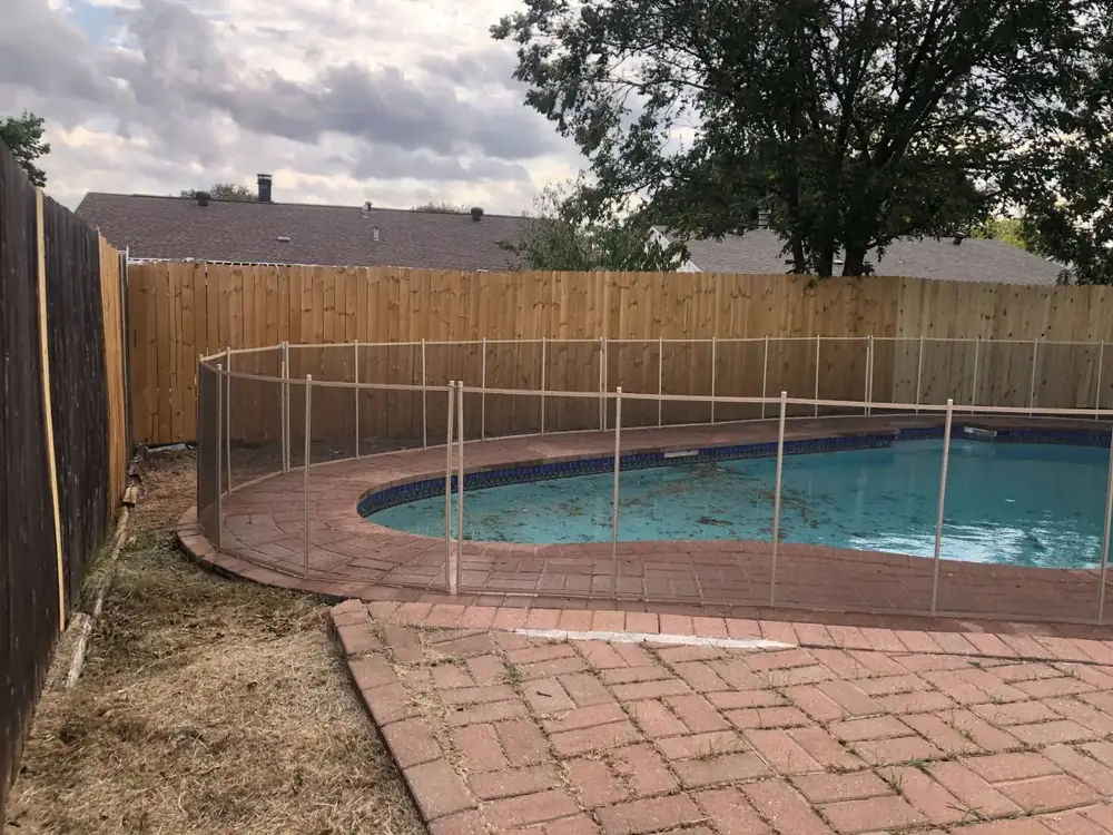 Tan mesh safety fence that blends with stone and deck