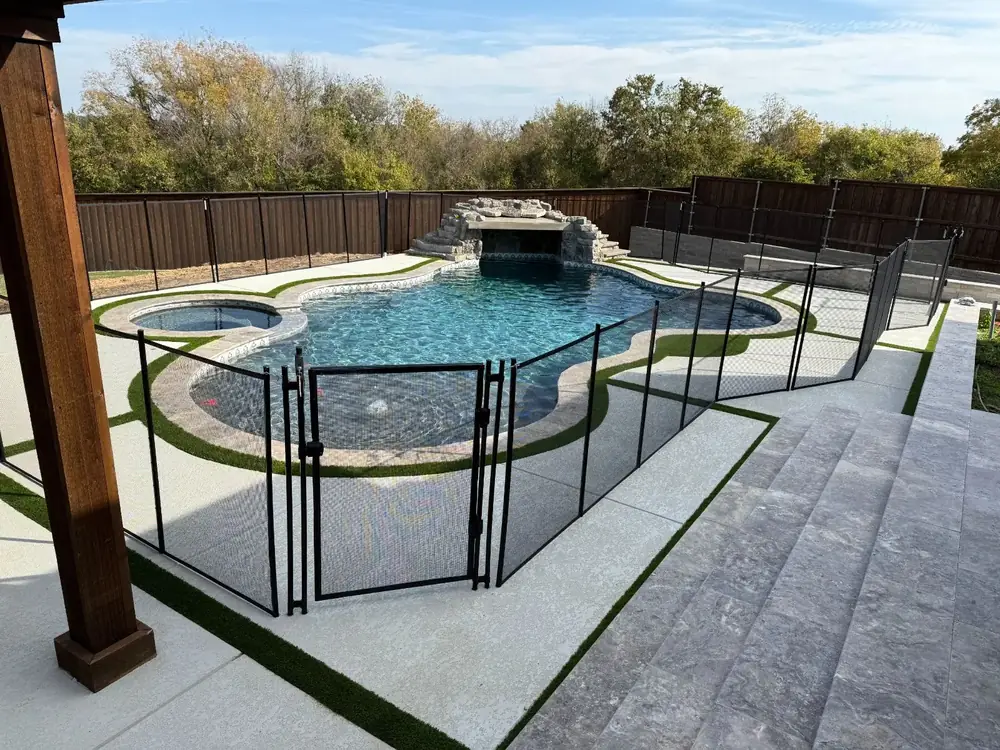 Black mesh safety fence around a backyard pool