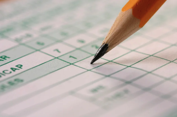 Sharpened pencil writing on sports scorecard