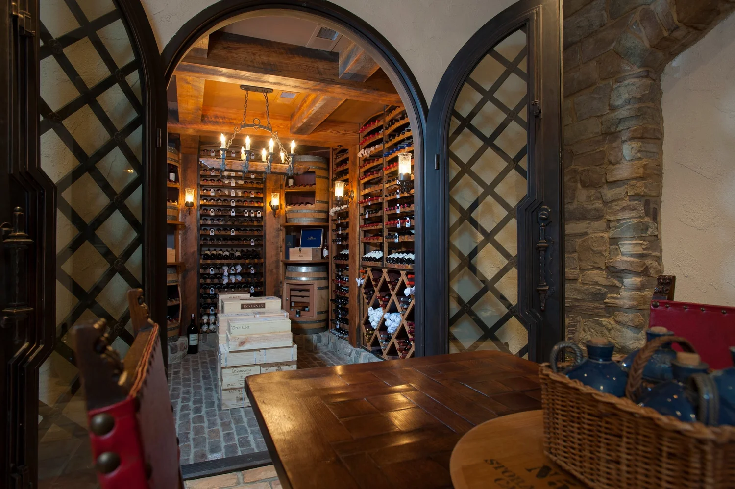 Luxury wine cellar with black cabinetry, gold accents, burgundy stone surfaces, and premium flooring