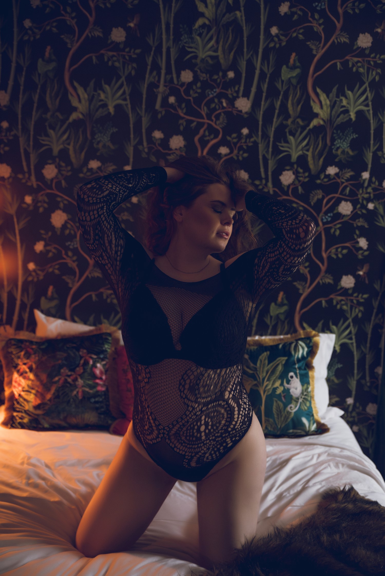 woman kneeling on bed wearing black lingerie