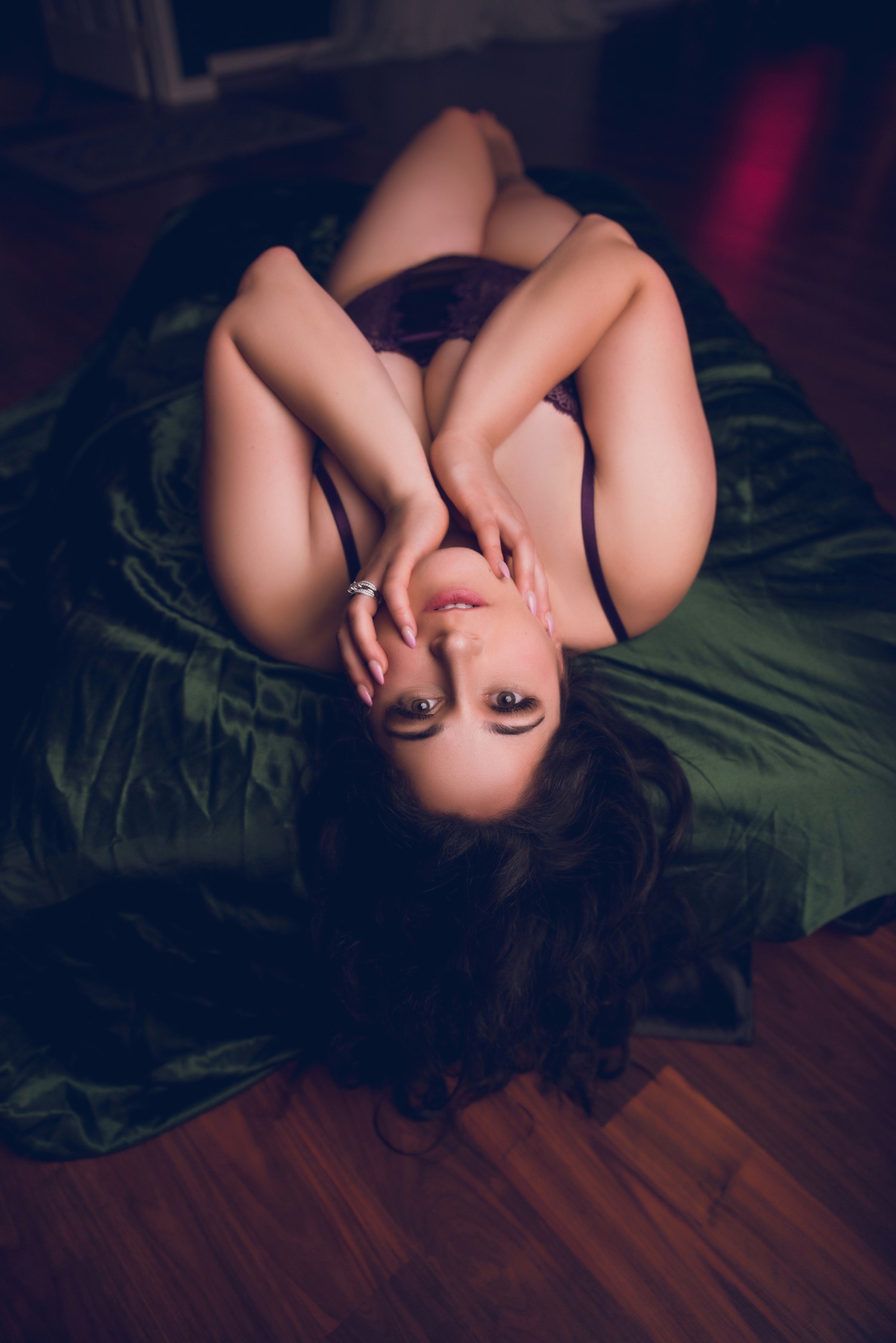 woman kneeling on floor with elbow on couch wearing black lingerie