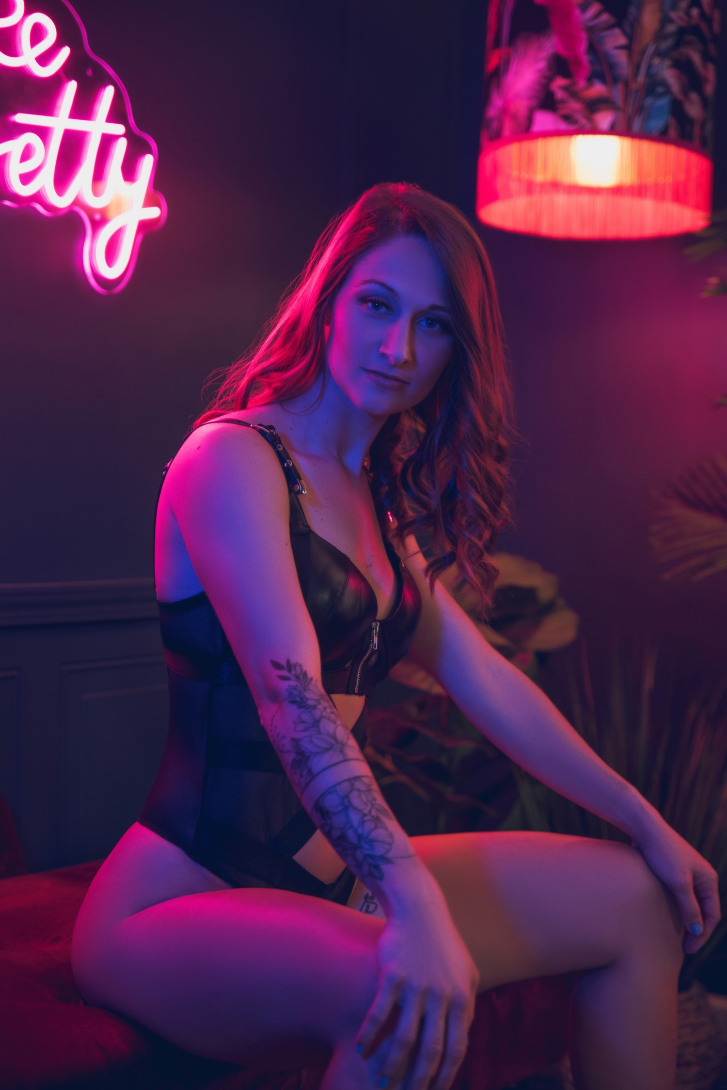 woman sitting while wearing black leather lingerie