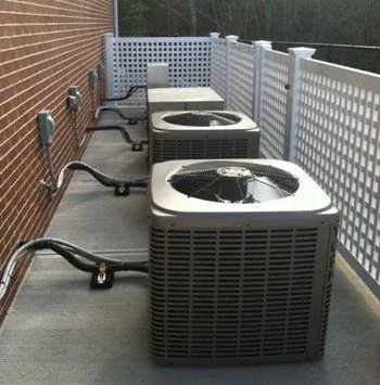 Twin condensers installed on a backyard deck