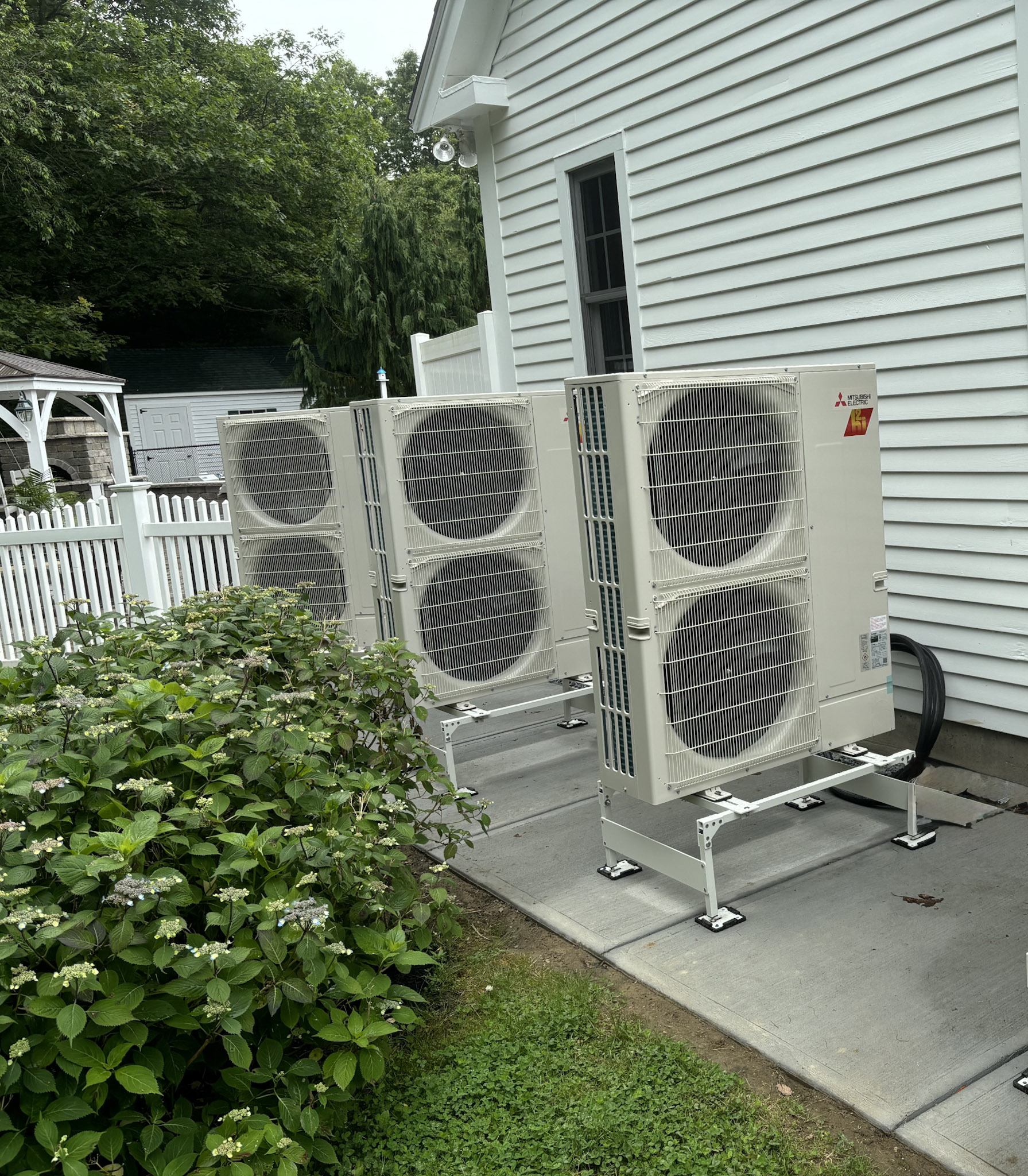 Ductless heat pump outdoor unit against home siding