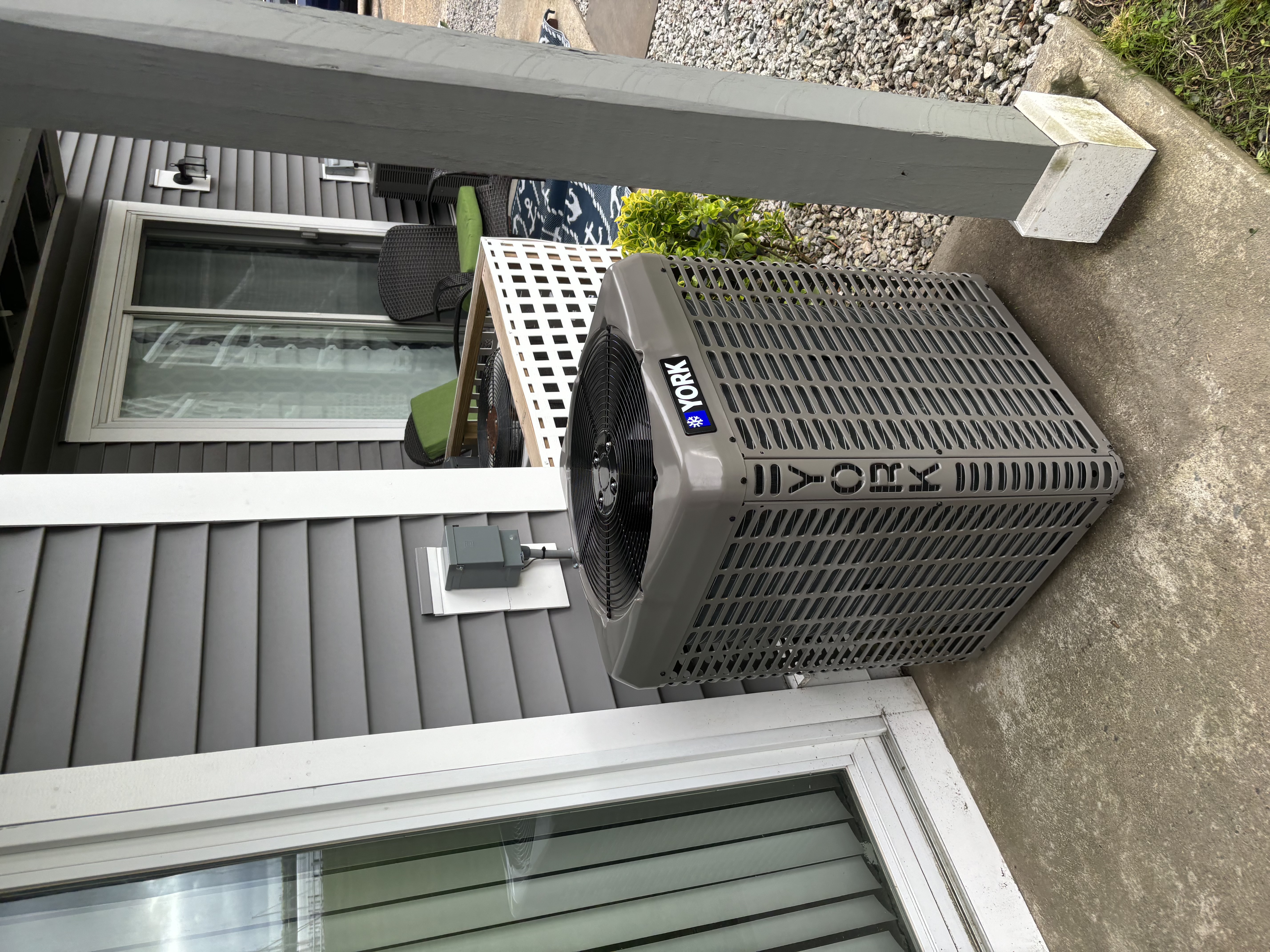 Condensers installed against a brick wall at a home