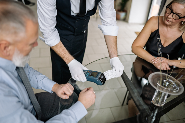 Man paying a waiter with a credit card Man paying a waiter with a credit card