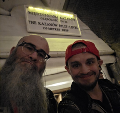 Man with long beard and man with red baseball cap on backwards, both smiling. Man with long beard and man with red baseball cap on backwards, both smiling.