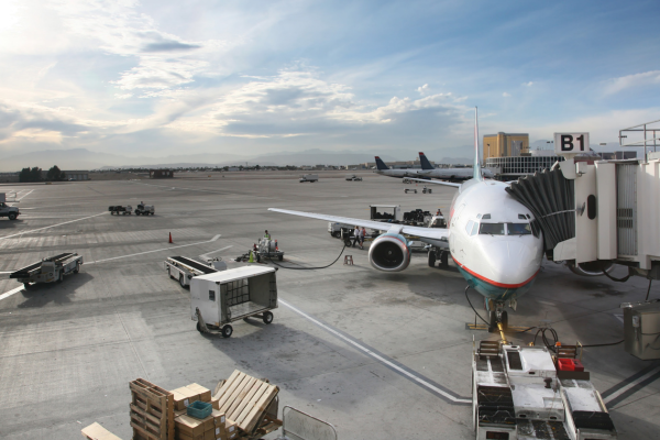 Plane on the tarmac with other airport ancilleries Plane on the tarmac with other airport ancilleries