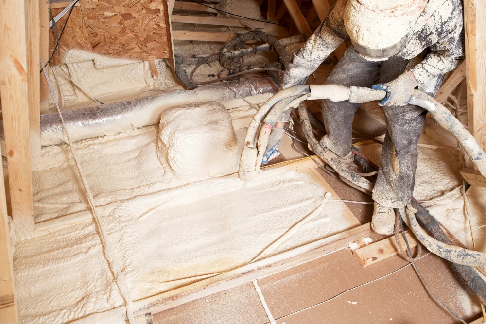 Technician installing closed-cell spray foam insulation in Panama City FL by Blue Line Insulation