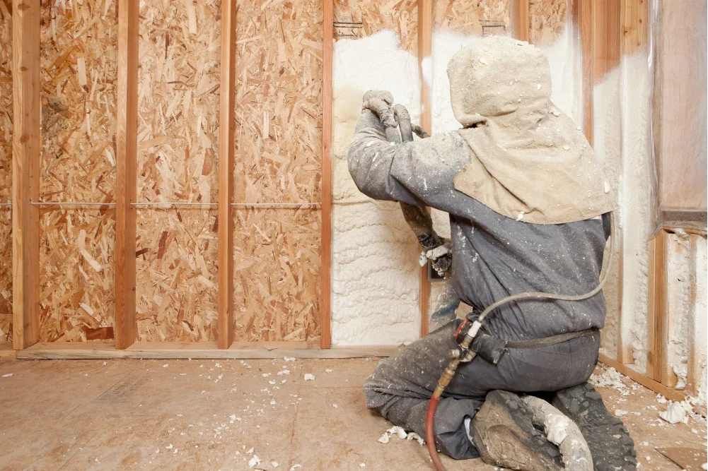 Technician applying closed-cell spray foam for indoor comfort in Panama City FL by Blue Line Insulation