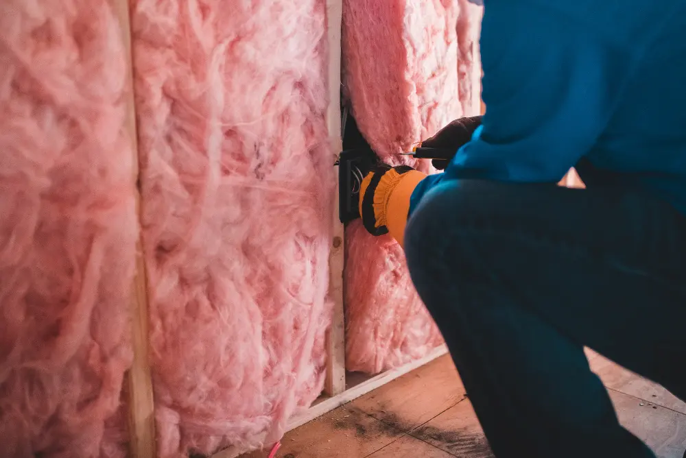 Installing fiberglass batts insulation in wall cavities in Panama City FL by Blue Line Insulation