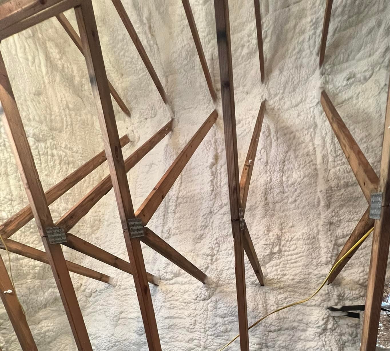 Closed cell spray foam insulation applied to rafters in Santa Rosa, FL for moisture resistance and energy savings