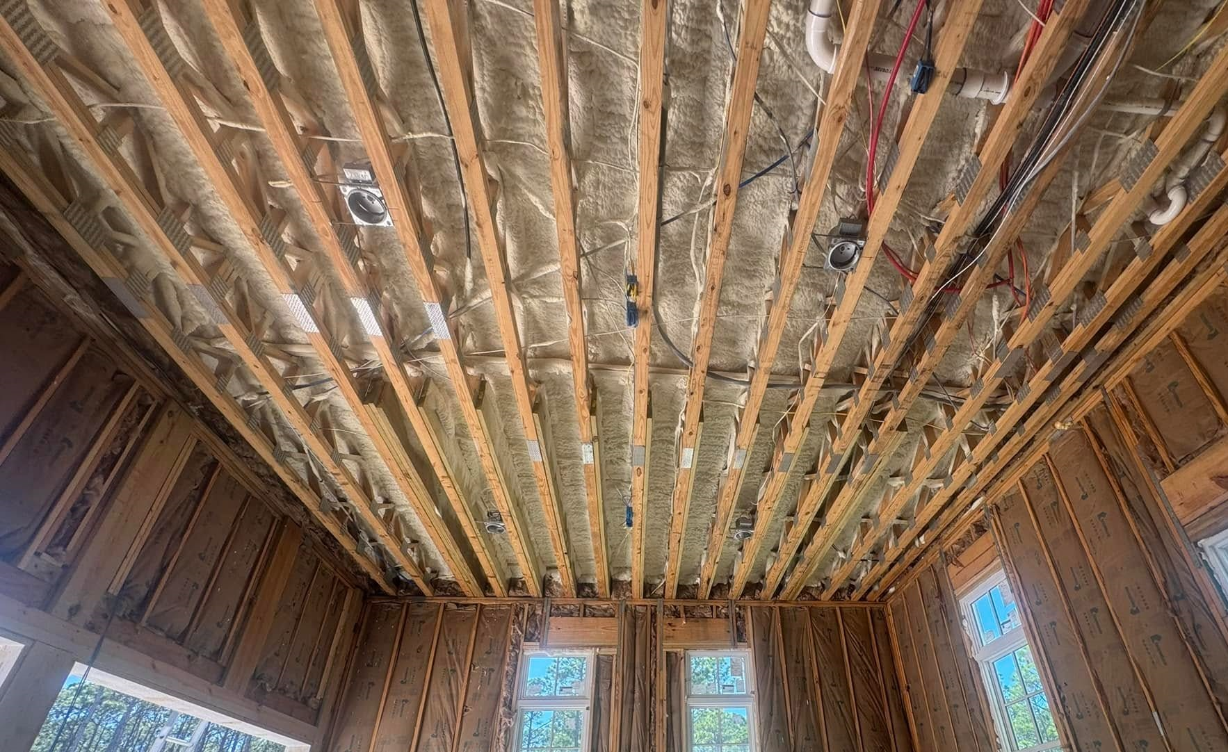 Blown-in insulation installed in ceiling joists for energy savings in Panama City FL by Blue Line Insulation