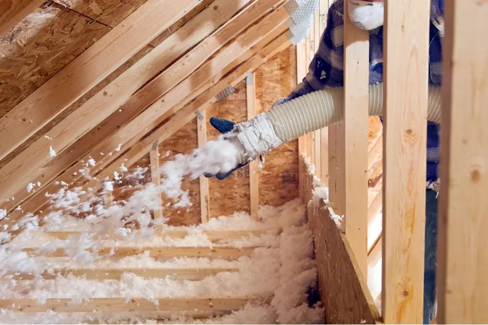 Blown-in attic insulation installed between rafters in Panama City FL by Blue Line Insulation
