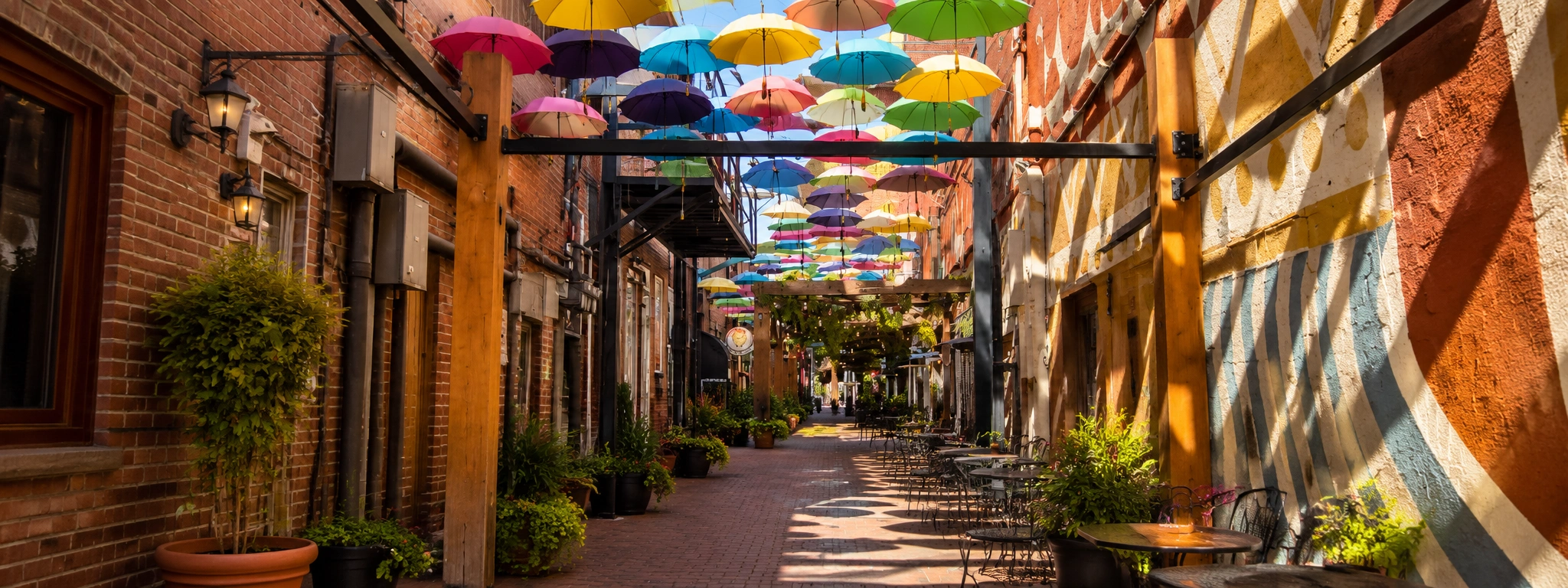 Orange Street Alley in Redlands California with colorful umbrellas, brick walls, and outdoor dining walkway