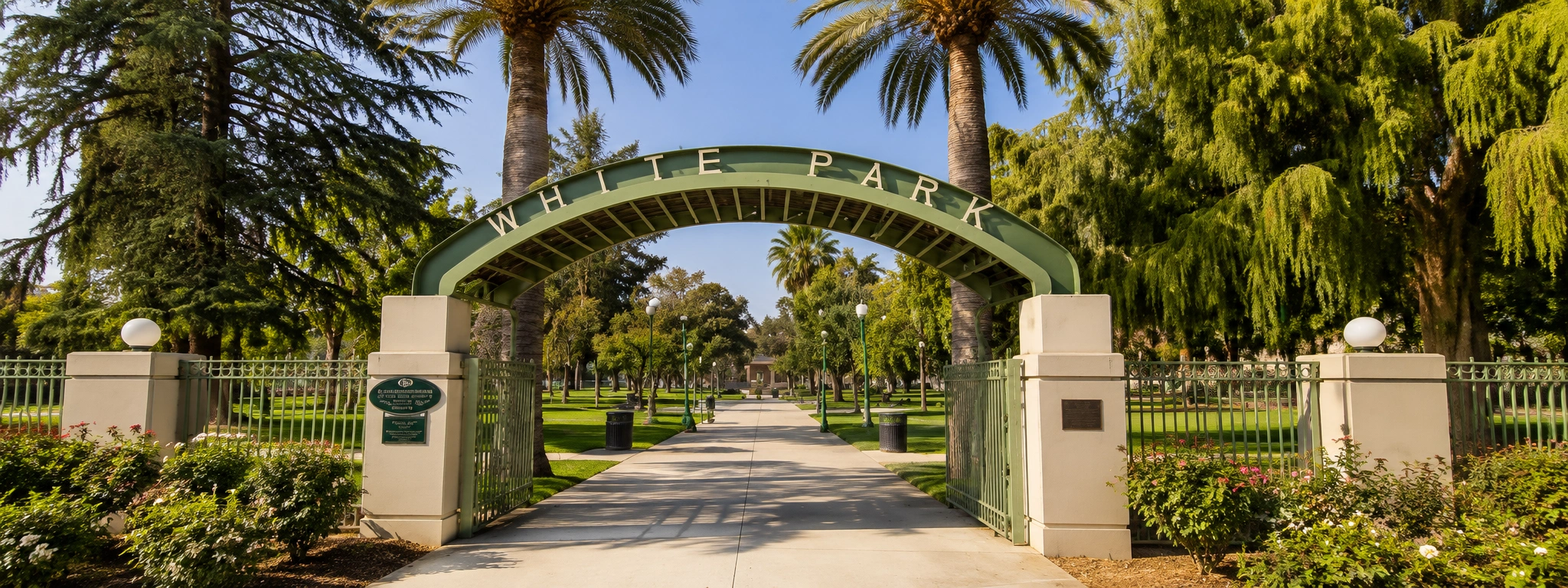 White Park in Riverside California with palm-lined entrance arch, landscaped walkways, and historic park grounds