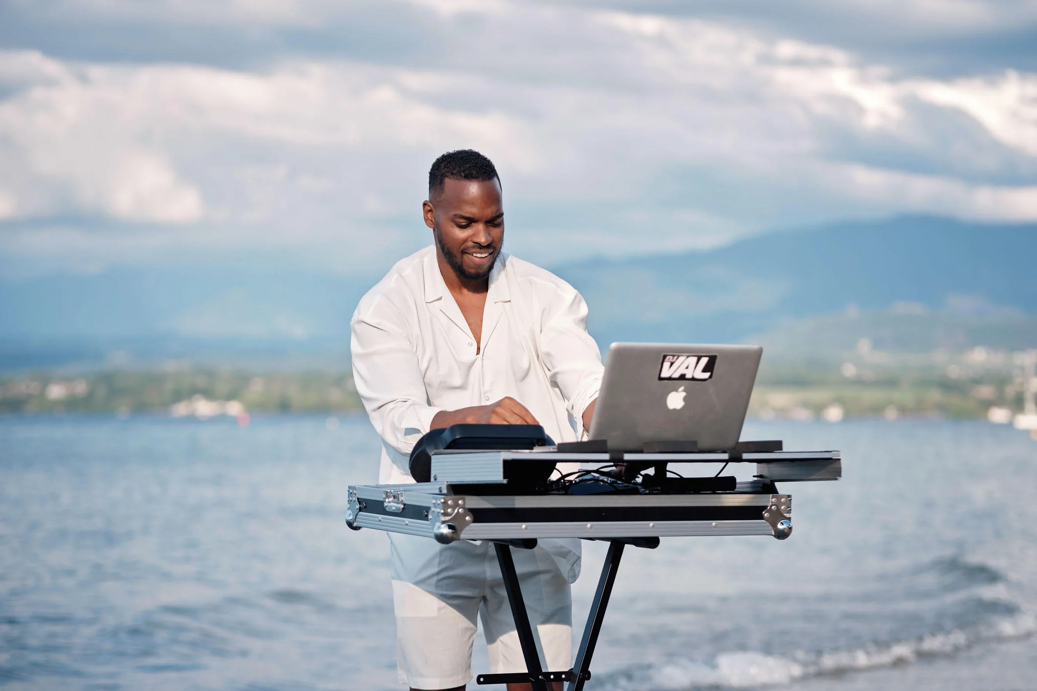 DJ en prestation en extérieur au bord du lac près de Genève, avec vue sur les montagnes.