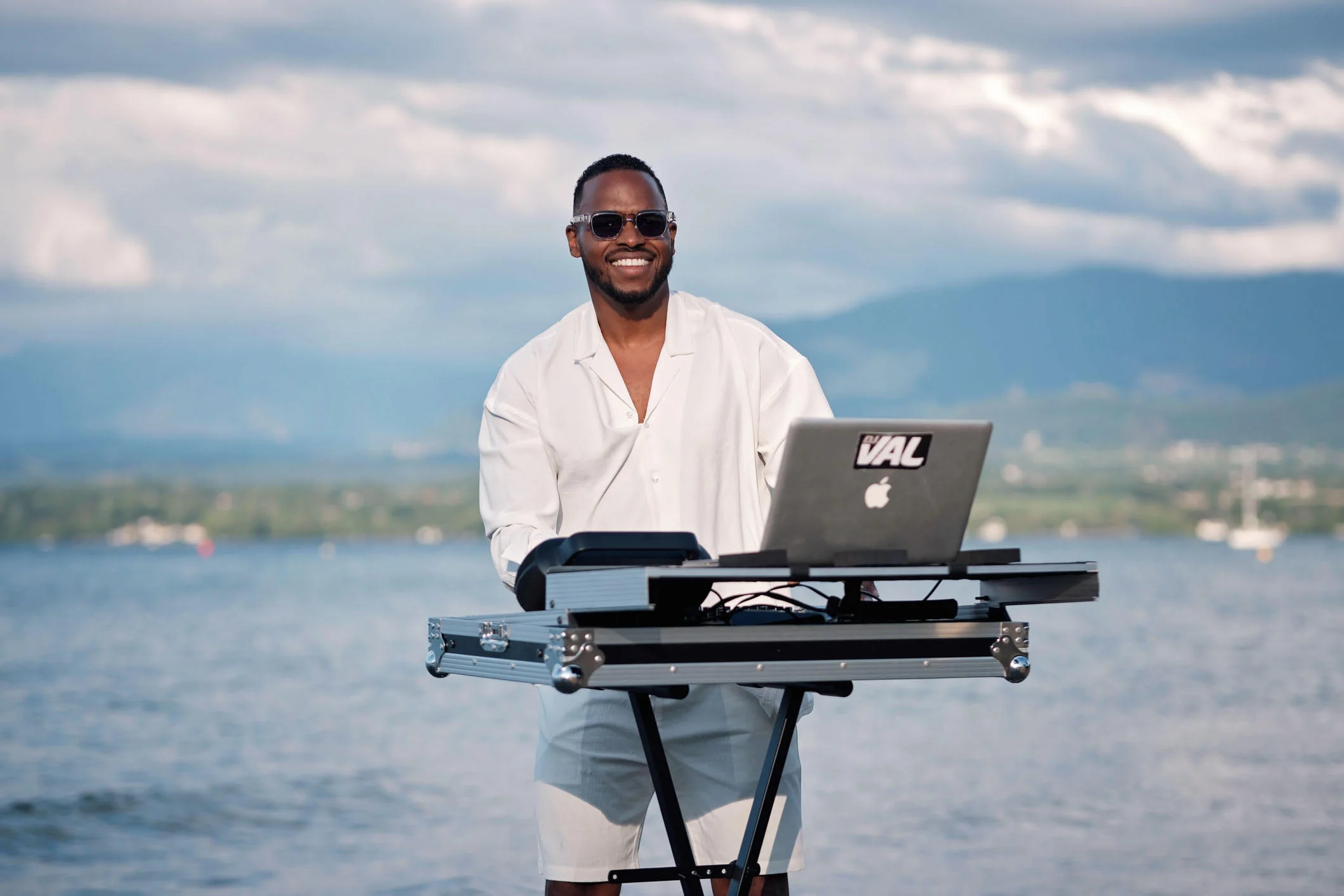 DJ en prestation en plein air au bord du lac, avec vue sur les montagnes près de Genève.