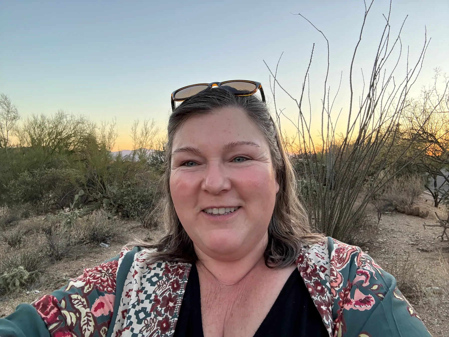 Kate smiling outdoors at golden hour