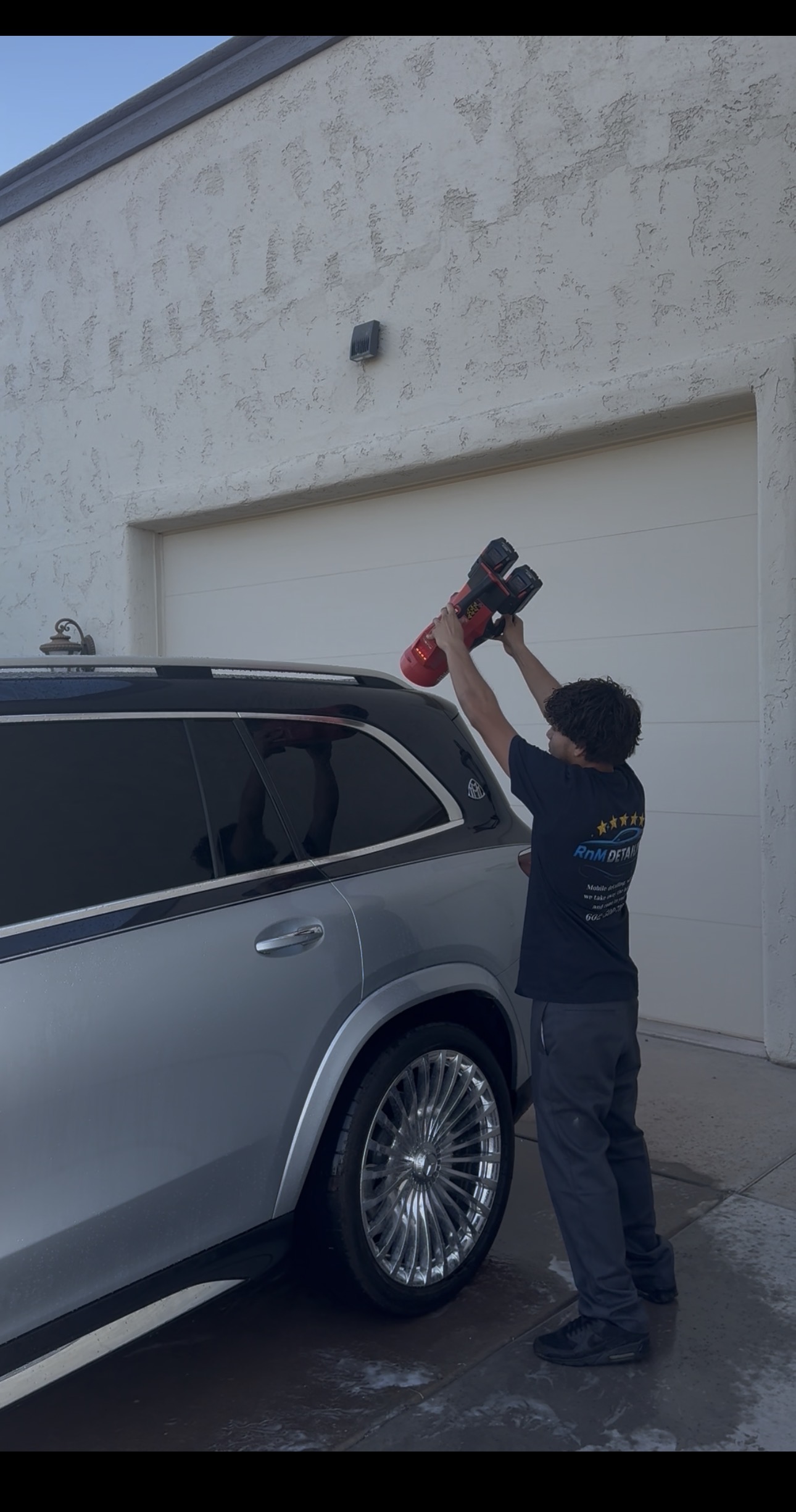 RnM Detailing team member detailing an SUV roofline