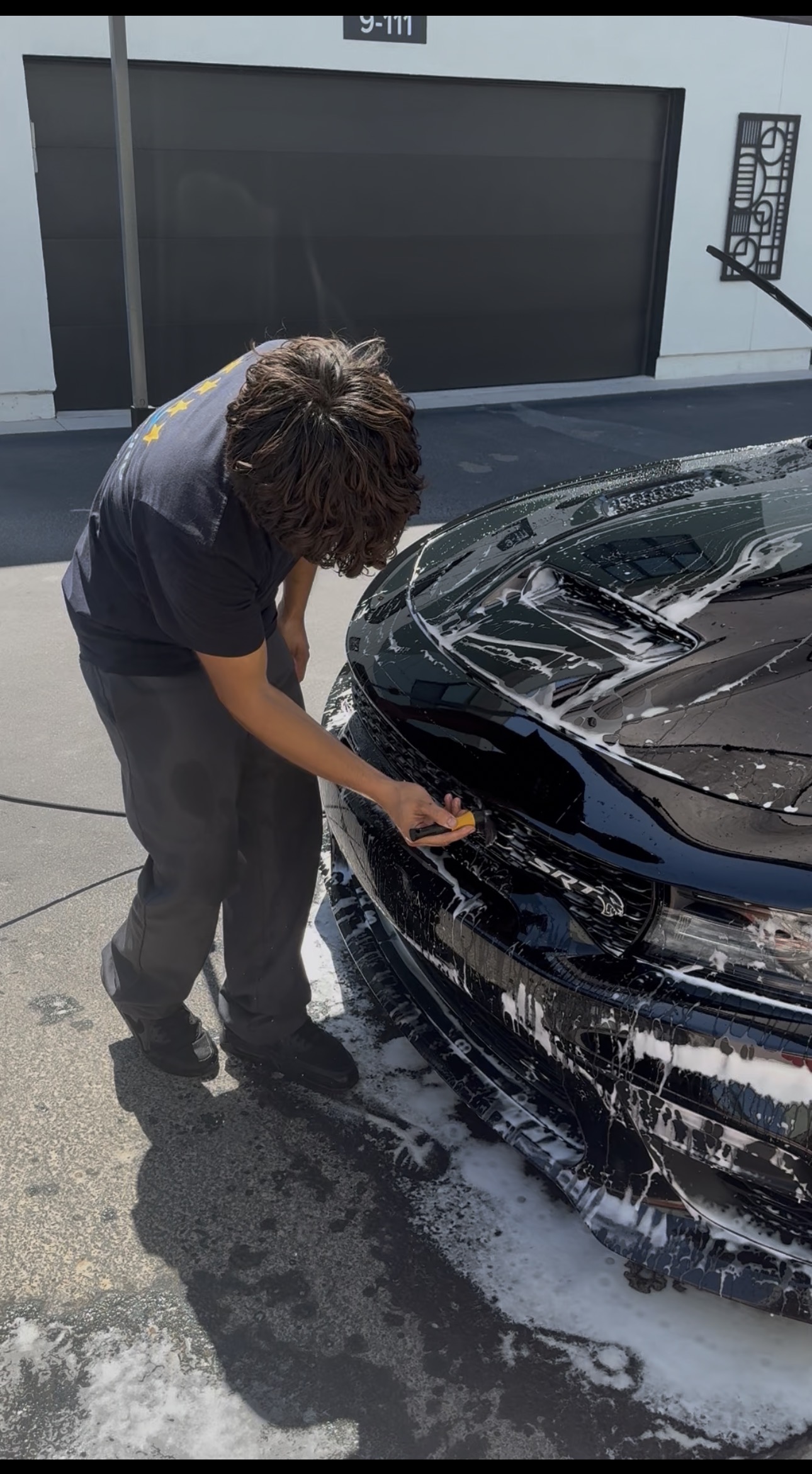 RnM Detailing team member foam washing a Dodge Charger