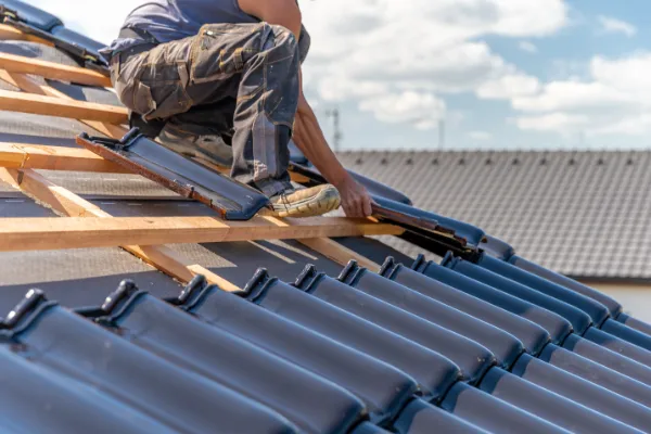 Roofer installing shingles