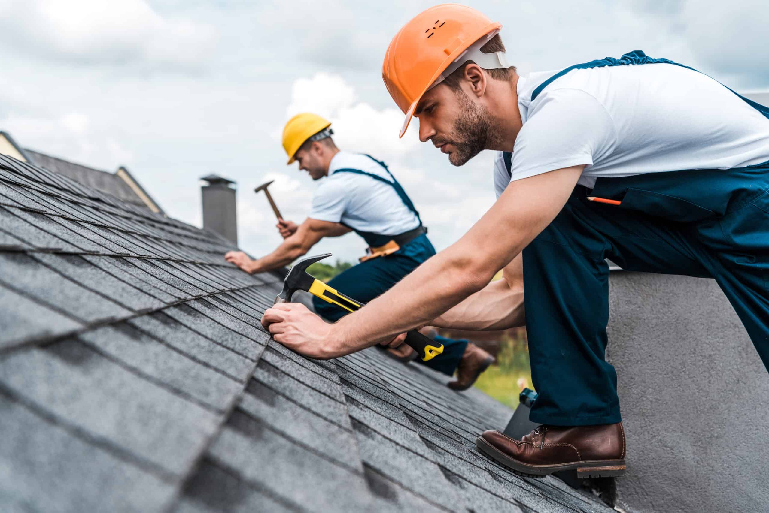 Technicians repairing shingles on a roof